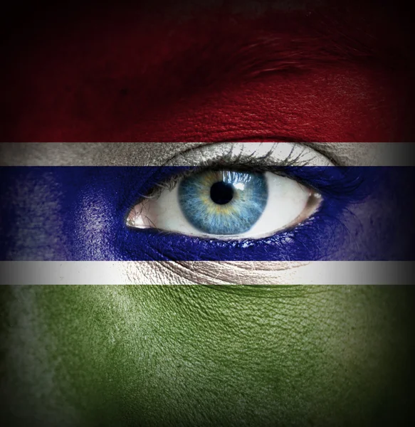 Human face painted with flag of Gambia — Stock Photo, Image