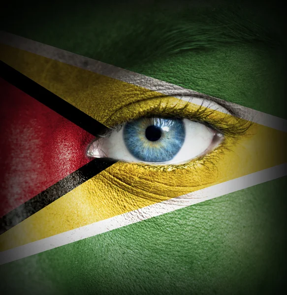 Human face painted with flag of Guyana — Stock Photo, Image