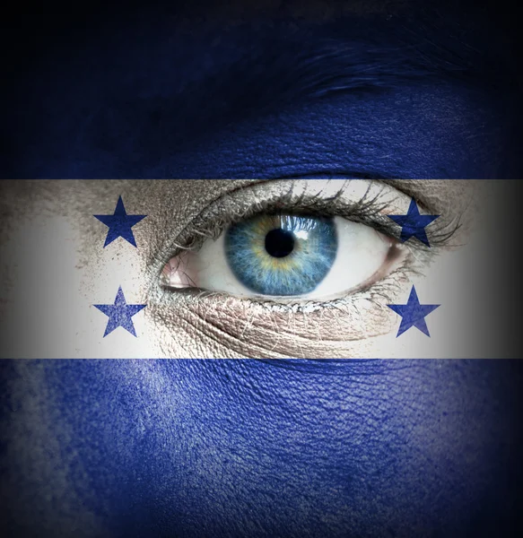 Mänskligt ansikte målade med honduras flagga — Stockfoto