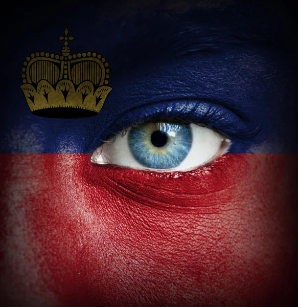 Human face painted with flag of Liechtenstein — Stock Photo, Image