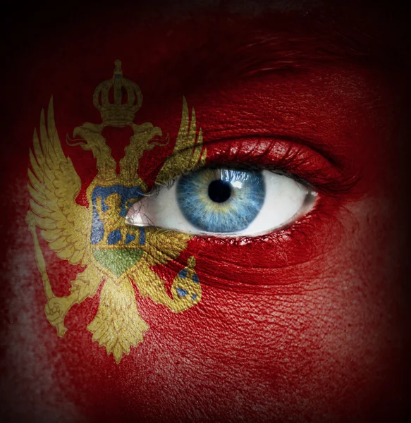 Human face painted with flag of Montenegro — Stock Photo, Image