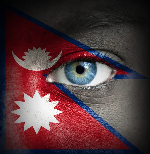 Human face painted with flag of Nepal — Stock Photo, Image