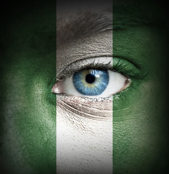 Mänskligt ansikte målade med flagga nigeria — Stockfoto