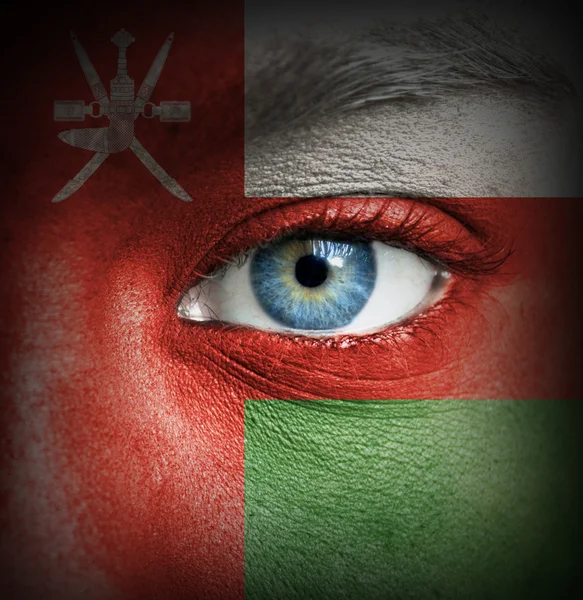 Human face painted with flag of Oman — Stock Photo, Image