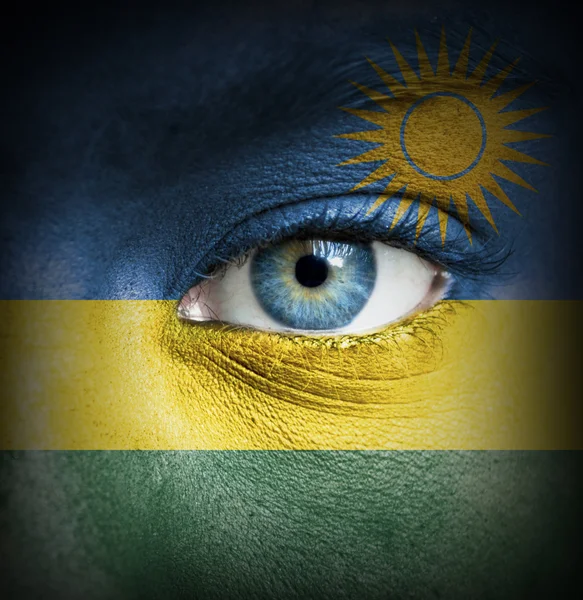 Visage humain peint avec le drapeau du Rwanda — Photo