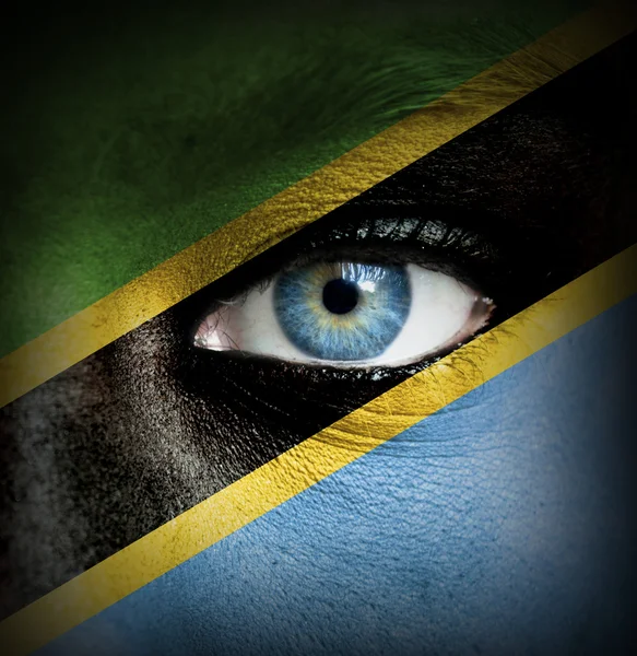 Human face painted with flag of Tanzania — Stock Photo, Image