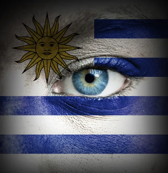 Menschengesicht mit uruguayischer Flagge bemalt — Stockfoto