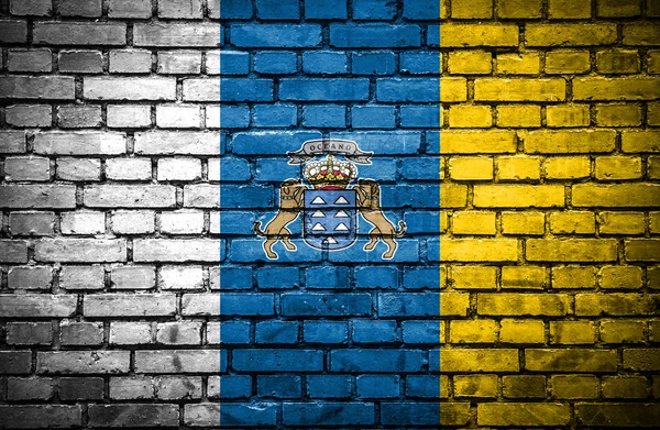 Cihlová zeď s malovanými vlajka Kanárských ostrovů — Stock fotografie