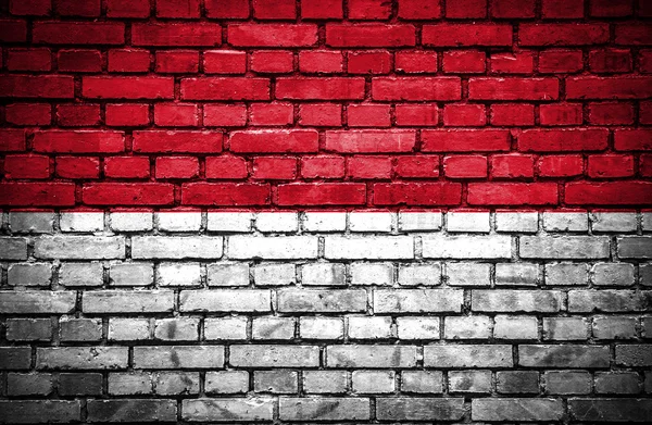 Кирпичная стена с окрашенным флагом Индонезии — стоковое фото