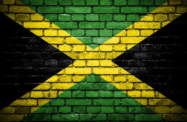 Кирпичная стена с раскрашенным флагом Ямайки — стоковое фото