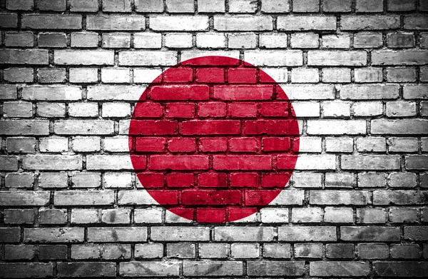 Cihlová zeď s malovanými japonská vlajka — Stock fotografie