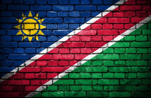 Bakstenen muur met geschilderde vlag van Namibië — Stockfoto