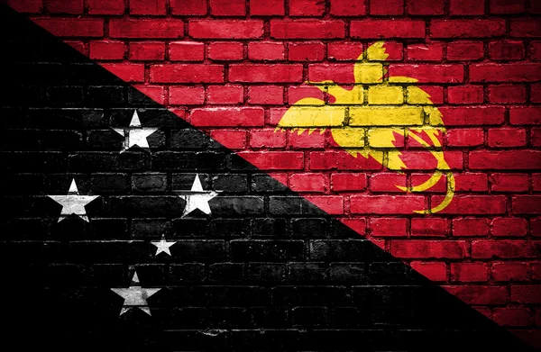 Cihlová zeď s malovanými vlajka Papuy-Nové Guineje — Stock fotografie