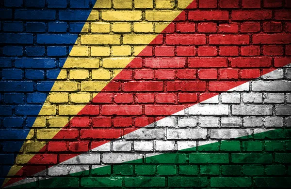 Backsteinmauer mit bemalter Flagge der Seychellen — Stockfoto