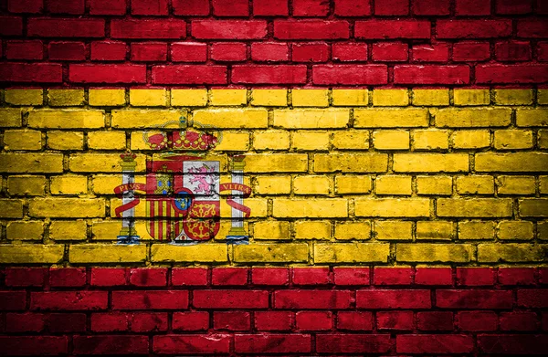 スペインの塗られた旗とレンガの壁 — ストック写真