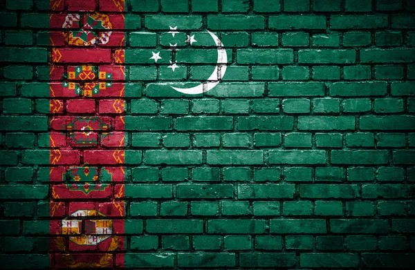 Кирпичная стена с окрашенным флагом Туркменистана — стоковое фото