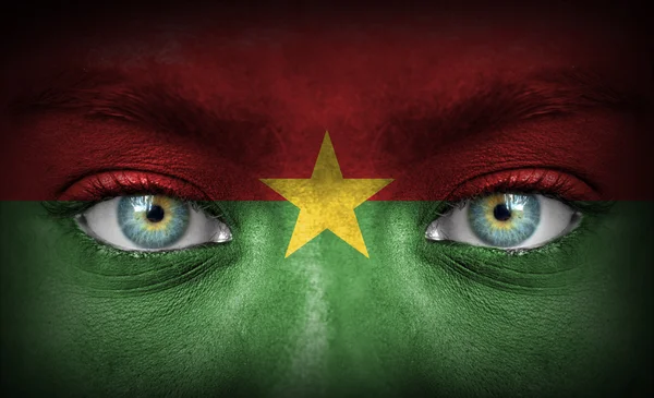 Human face painted with flag of Burkina Faso — Stock Photo, Image