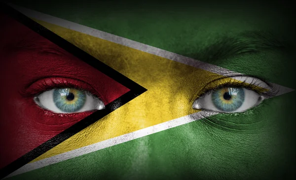 Menschengesicht mit Flagge aus Guyana bemalt — Stockfoto