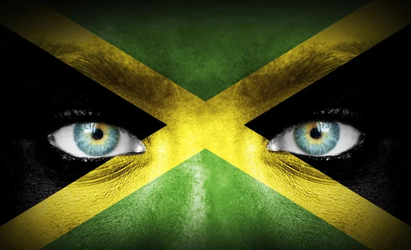 Menselijk gezicht beschilderd met vlag van jamaica — Stockfoto