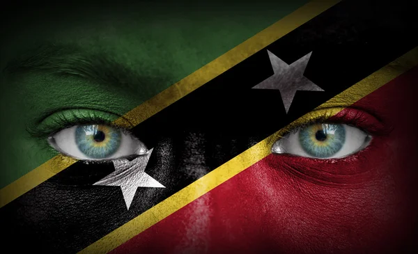 Menschengesicht bemalt mit Flagge der Heiligen Kitts und Nevis — Stockfoto