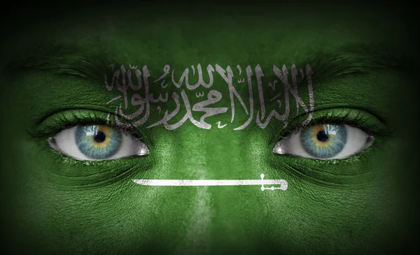 Mänskligt ansikte målade med flagga Saudiarabien — Stockfoto
