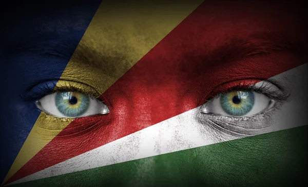 Human face painted with flag of Seychelles — Stock Photo, Image
