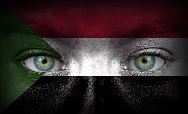 Lidská tvář s Súdánská vlajka — Stock fotografie