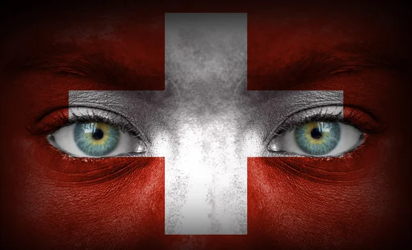 Human face painted with flag of Switzerland — Stock Photo, Image