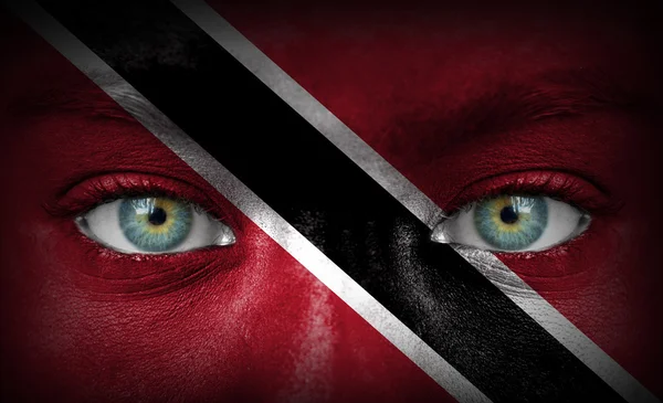 Человеческое лицо, нарисованное флагом Тринидада и Тобаго — стоковое фото