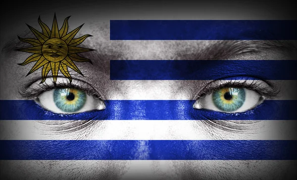 Human face painted with flag of Uruguay — Stock Photo, Image