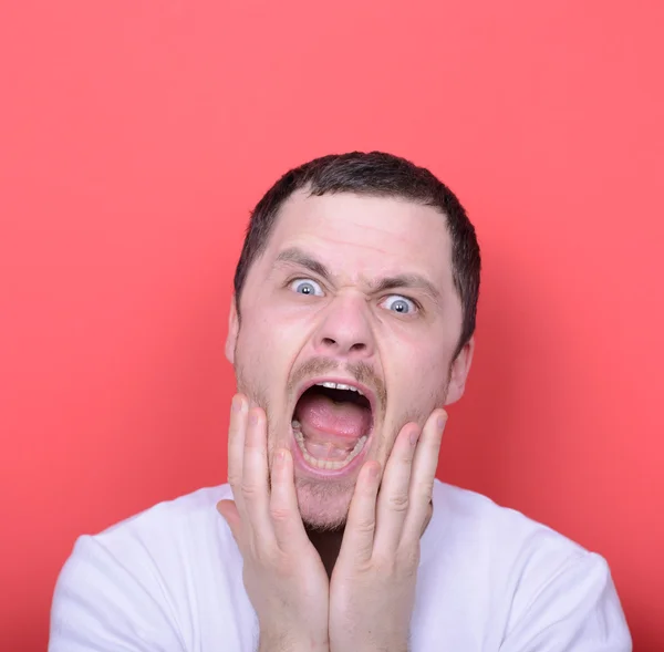 Portrait of angry man screaming against red background — Stock Photo, Image