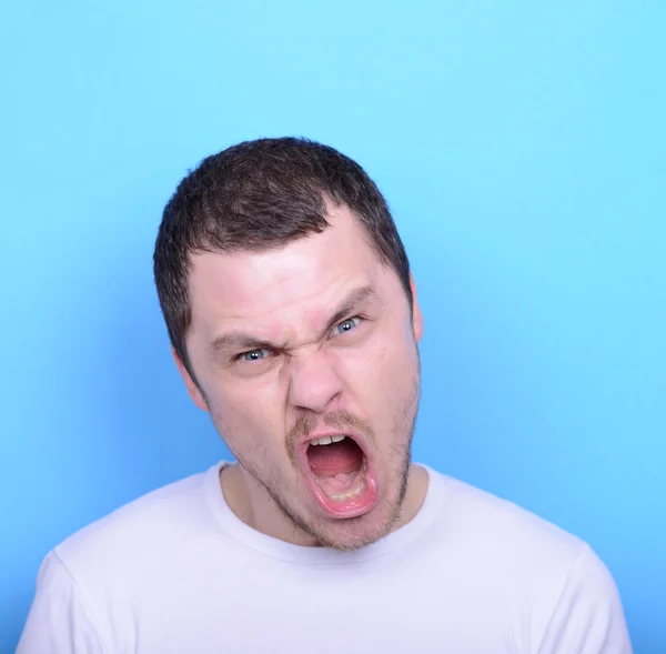 Retrato de hombre enojado gritando y tirando de pelo contra ba azul — Foto de Stock