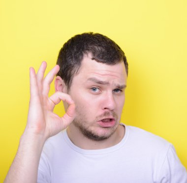 Portrait of funny man showing OK gesture with hands against yell