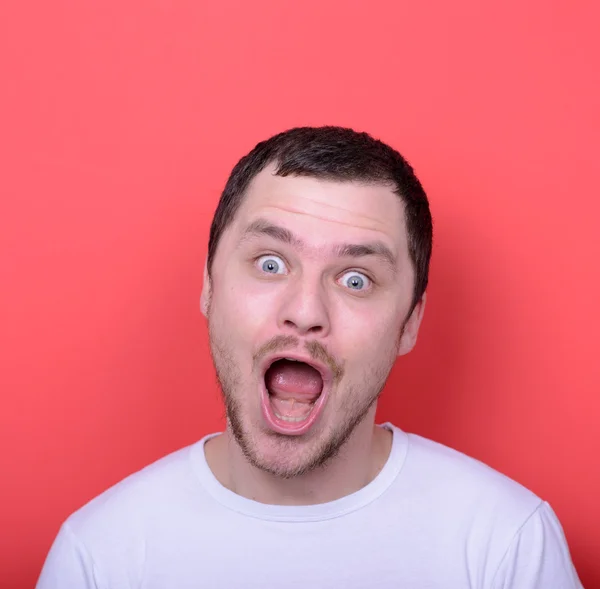 Retrato de hombre con cara divertida sobre fondo rojo — Foto de Stock