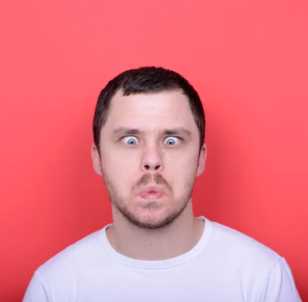 Portrait of man with funny face against red background — Stock Photo, Image