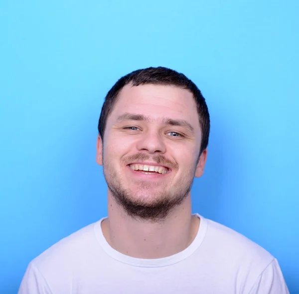 Portret van knappe man die lacht tegen blauwe achtergrond — Stockfoto