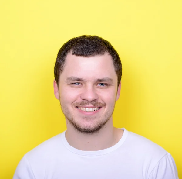 Portrait of handsome man smiling against yelllow background — Stock Photo, Image