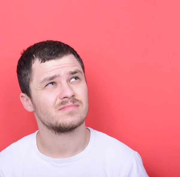 Portrait of man thinking against red background — Stock Photo, Image