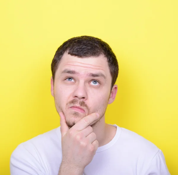 Retrato del hombre pensando y mirando hacia arriba contra el fondo amarillo —  Fotos de Stock