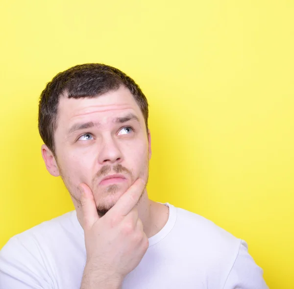 Retrato del hombre pensando y mirando hacia arriba contra el fondo amarillo —  Fotos de Stock