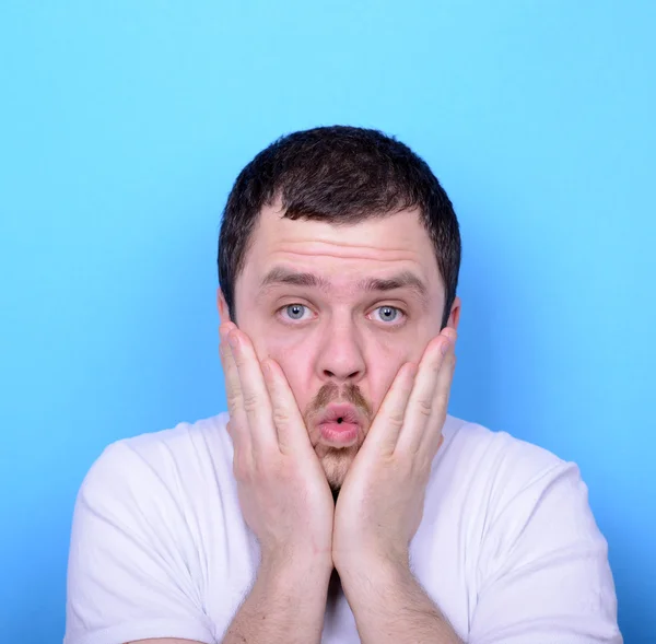 Portrait of man with dusgusted gesture against blue background — Stock Photo, Image