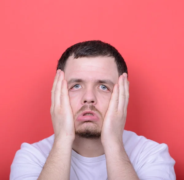 Portrait of man with dusgusted gesture against red background — Stock Photo, Image