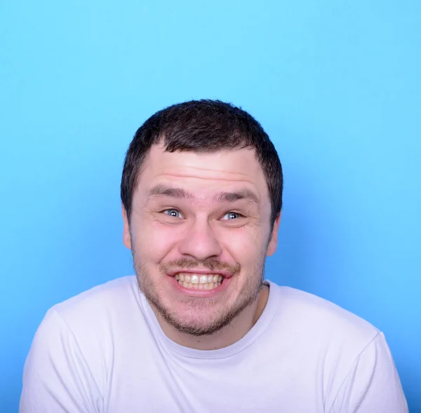 Портрет человека со смешным лицом на синем фоне — стоковое фото