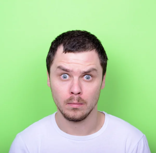 Portret van man met grappige gezicht tegen groene achtergrond — Stockfoto