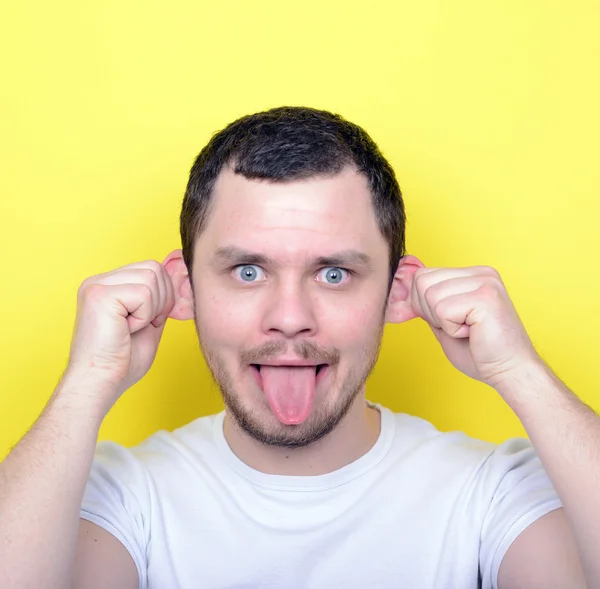 Портрет человека со смешным лицом на жёлтом фоне — стоковое фото