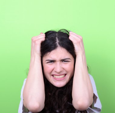 yeşil arka plana karşı saç çekerek kızgın kız portresi