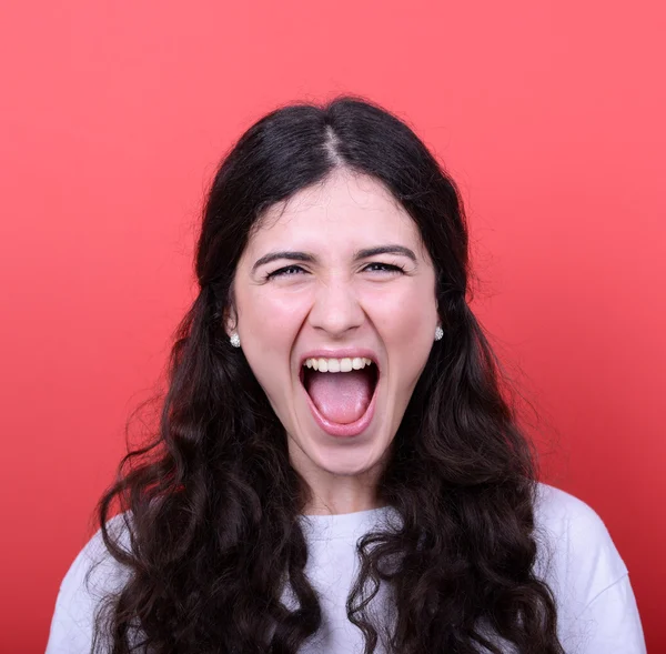 Portret van boos meisje schreeuwen tegen rode achtergrond — Stockfoto