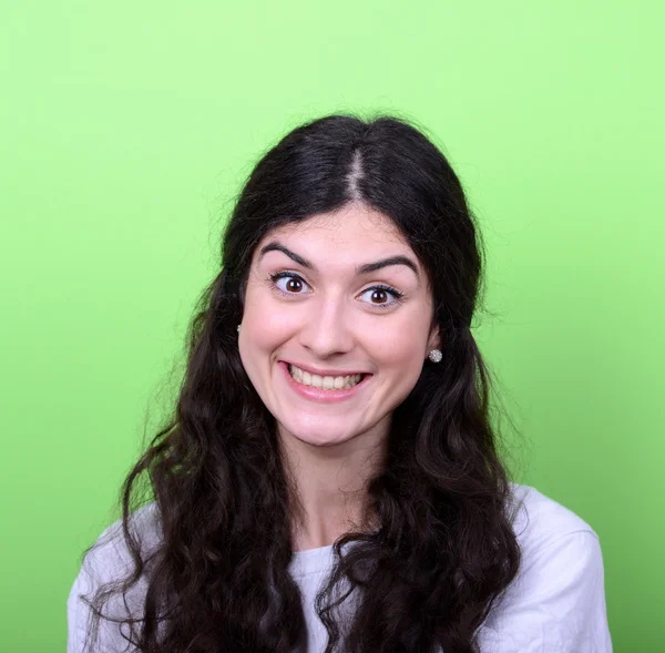 Retrato de una hermosa joven sonriendo contra un fondo verde — Foto de Stock