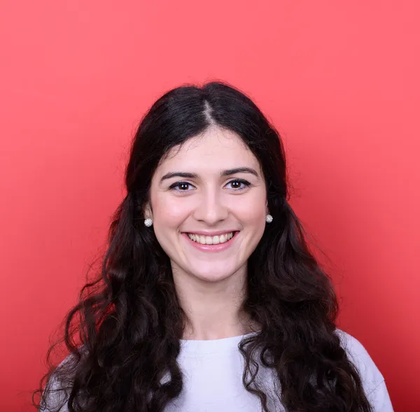 Retrato de una hermosa joven sonriendo sobre fondo rojo — Foto de Stock