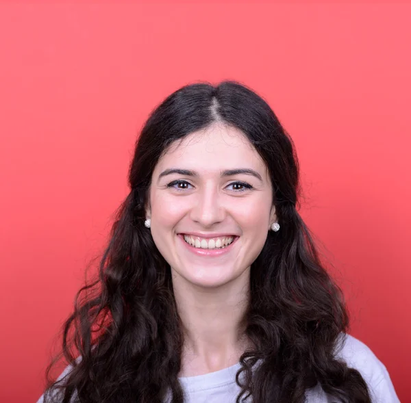 Retrato de una hermosa joven sonriendo sobre fondo rojo — Foto de Stock